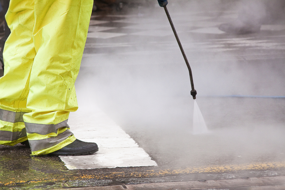 A worker cleaning the streets with water pressure